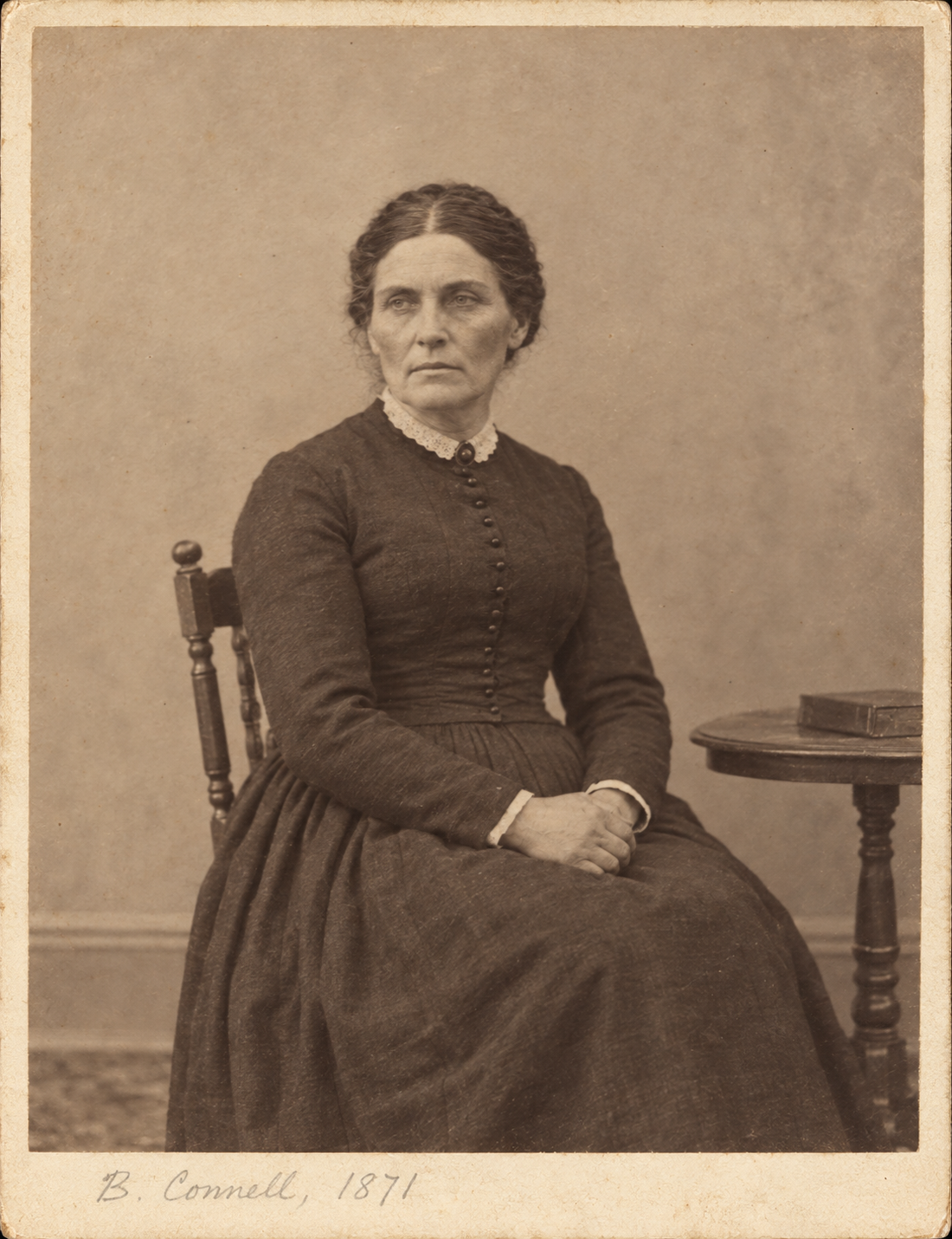 Cabinet card portrait inscribed 'B. Connell, 1871' on the mount, seated woman in dark dress, serious expression